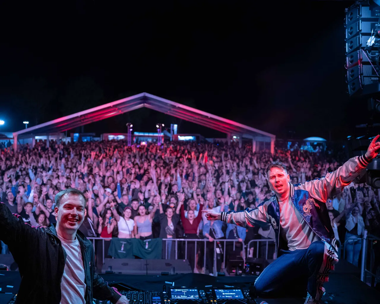 AXMO auf der Bühne und Crowd reißen Hände hoch.