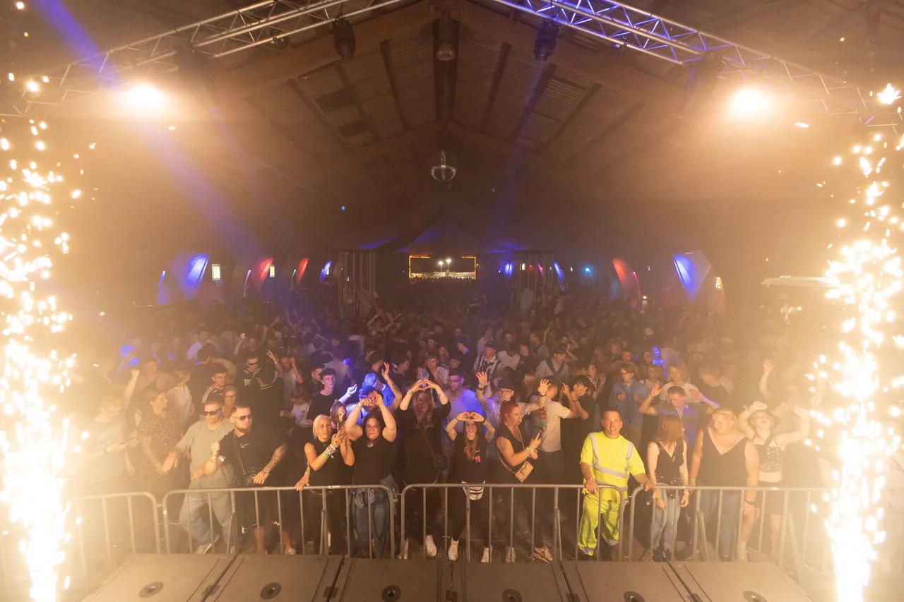 Crowd in Scheune mit Händen hoch